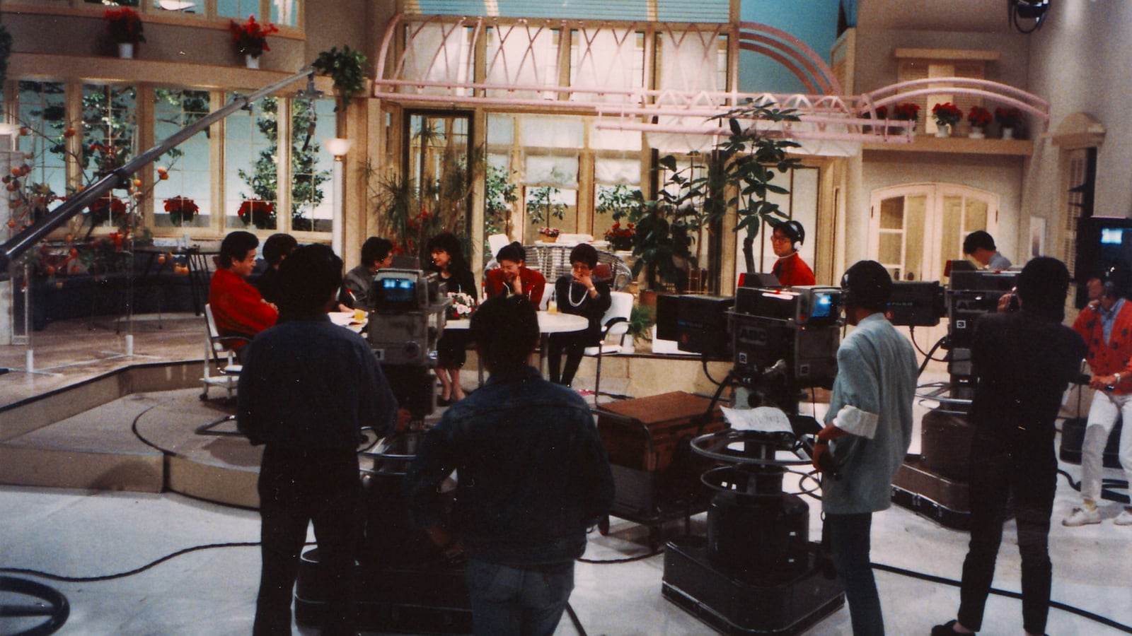 A television studio floor with cameras and warm lights